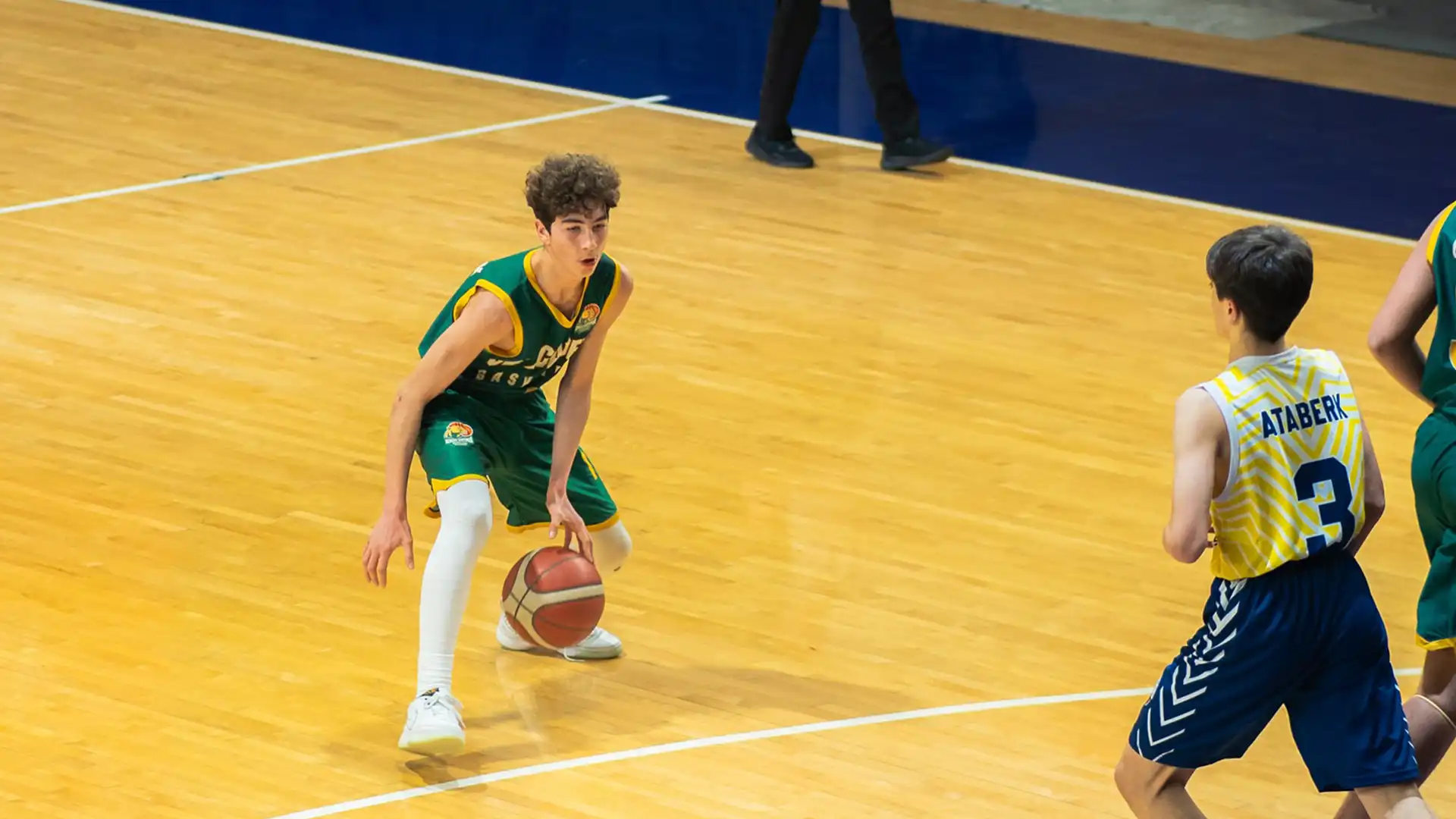 Basketbol eğitimi sırasında bire bir mücadele eden genç oyuncular