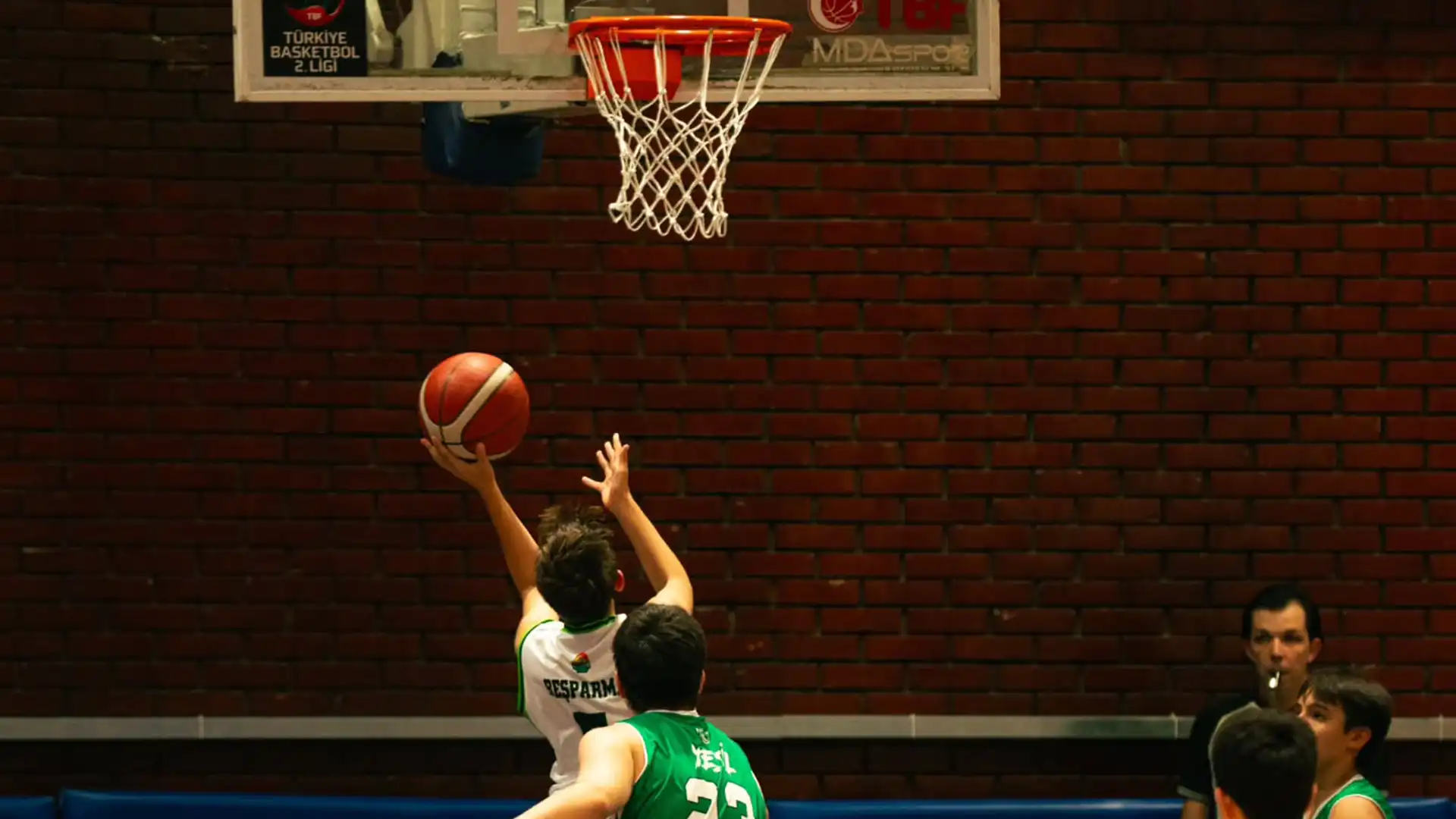Ankara basketbol okulu öğrencileri maç sırasında potaya sayı atıyor