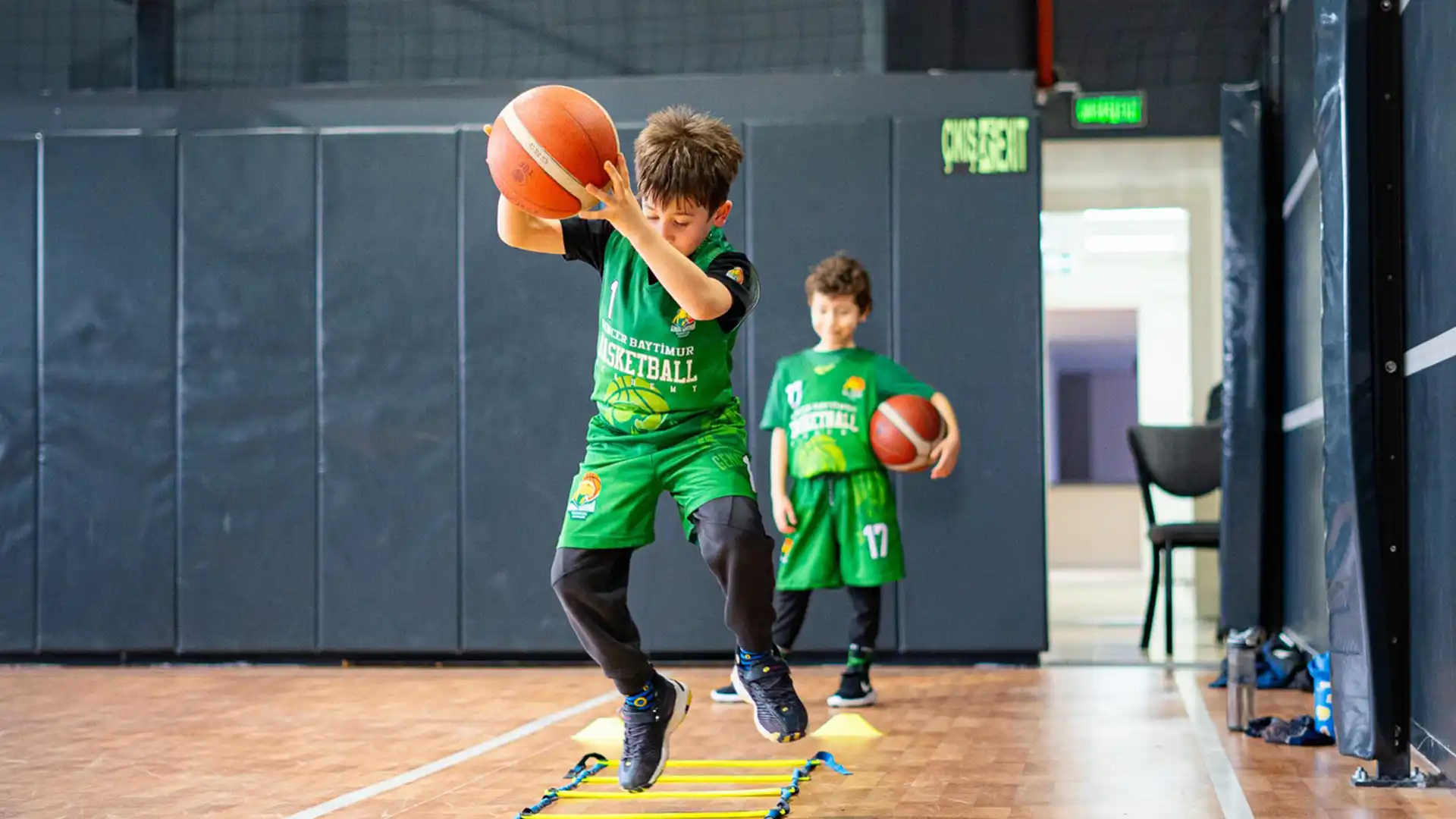 Gölbaşı Basketbol Kursu kapsamında antrenman yapan sporcu, koordinasyon merdiveni üzerinde top hakimiyeti, denge ve çeviklik becerilerini geliştirmeye yönelik çalışma gerçekleştiriyor.