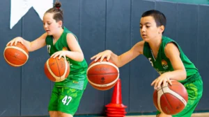Basketbol ayakkabısı ile antrenmanda çift topla top süren çocuk sporcular, Gencer Baytimur Basketbol Akademisi