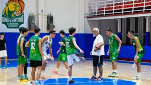 Basketbolda ısınma hareketleri yapan genç sporcular ve antrenör, Gencer Baytimur Basketbol Akademisi salonunda
