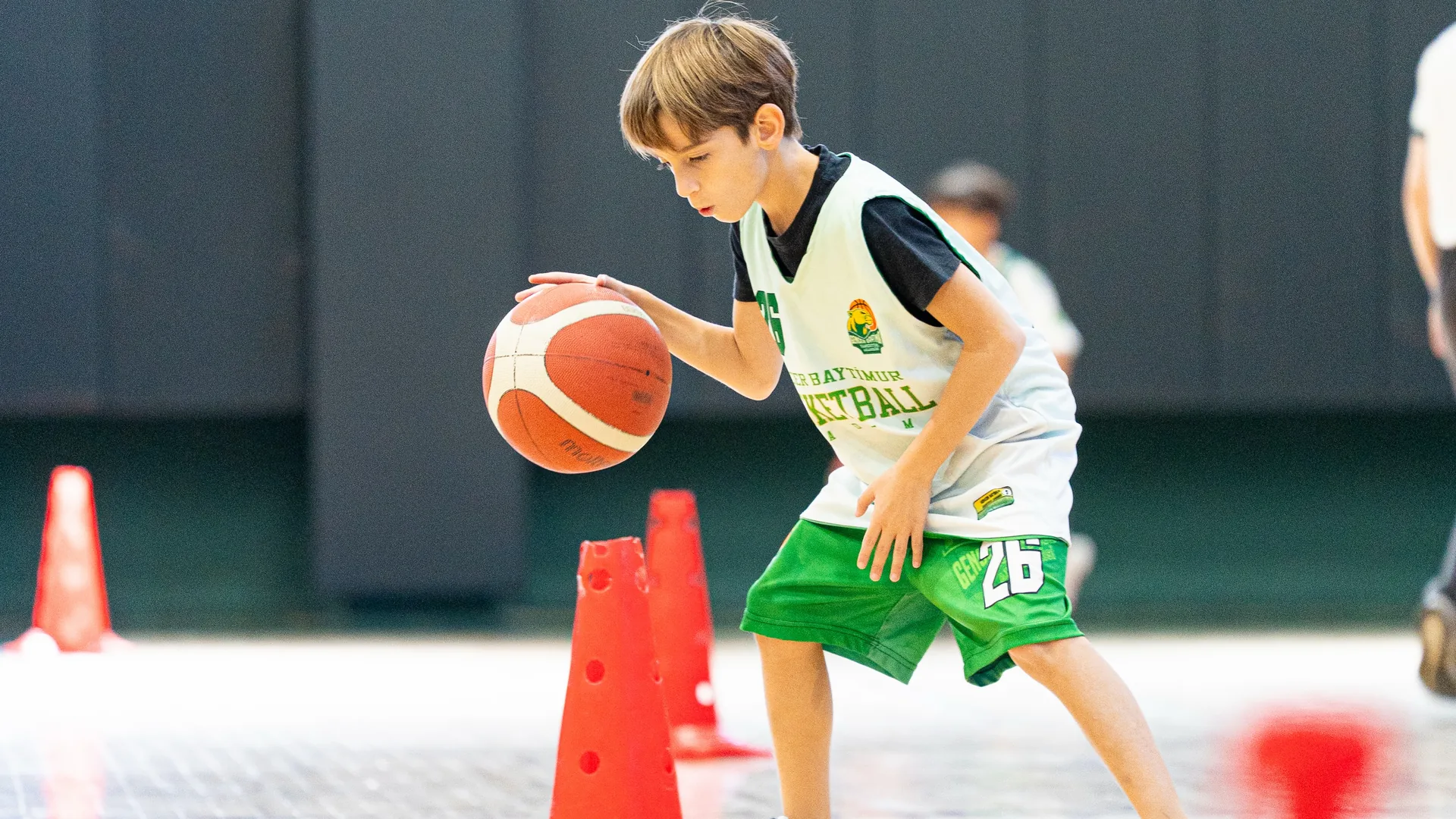 Gencer Baytimur Basketbol Akademisi'nde koniler arasında top sürme çalışan çocuk
